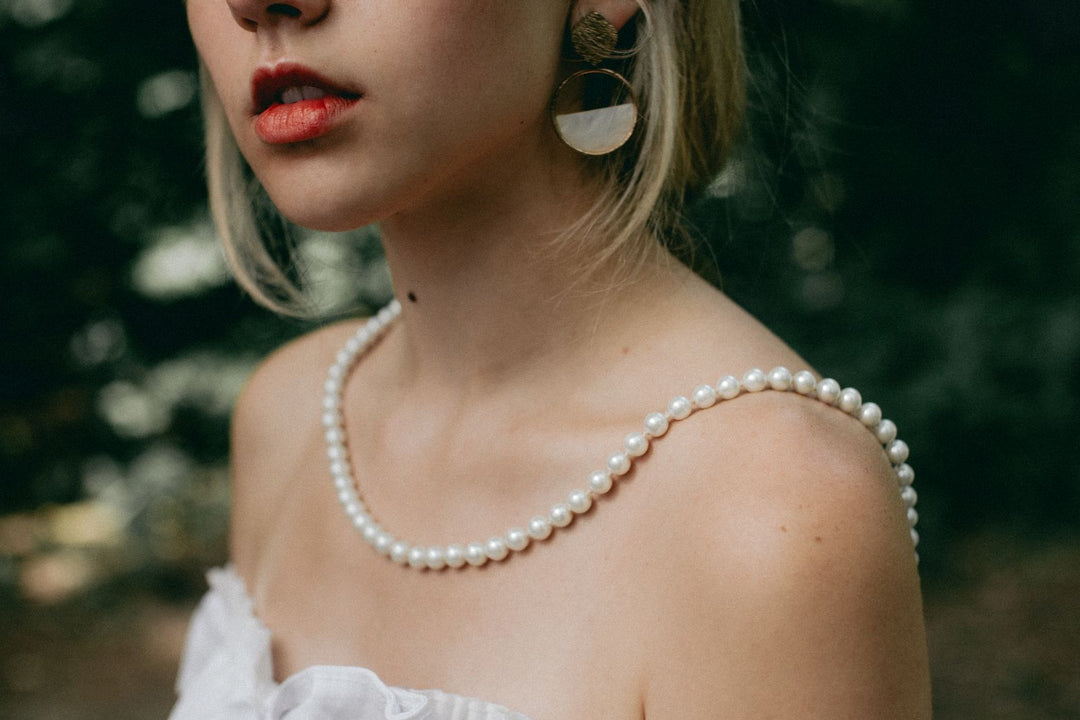 Woman wearing a white pearl necklace in natural daylight
