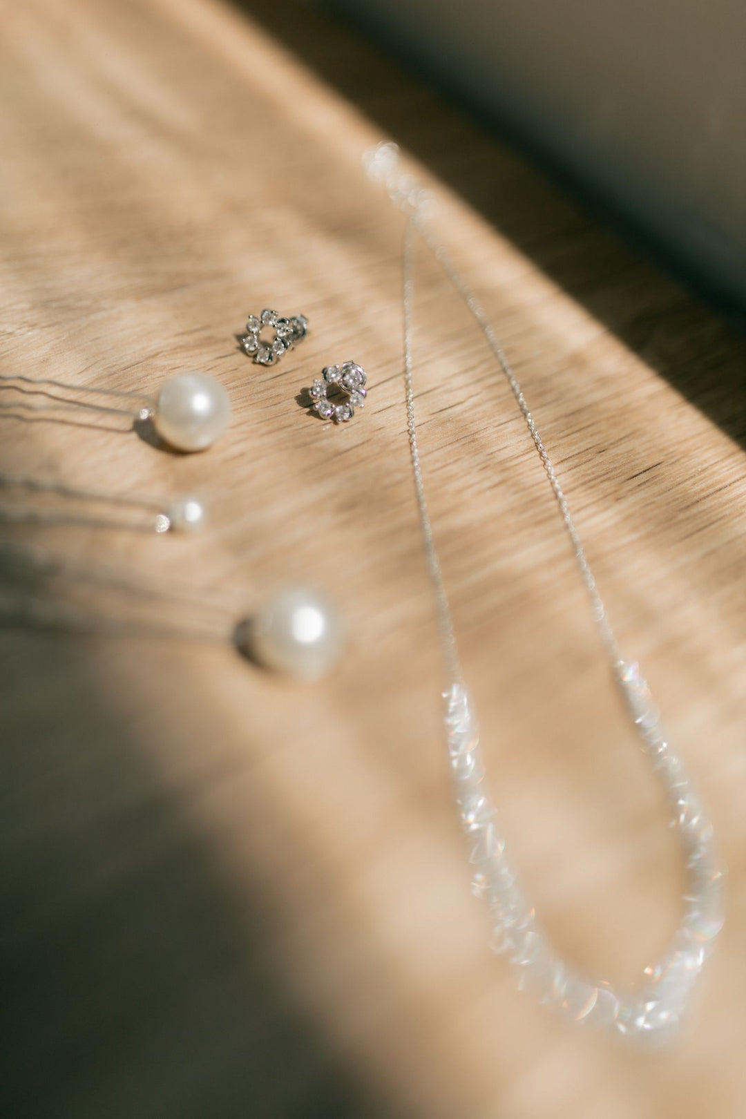 Pearl earrings and diamond jewelry arranged side by side