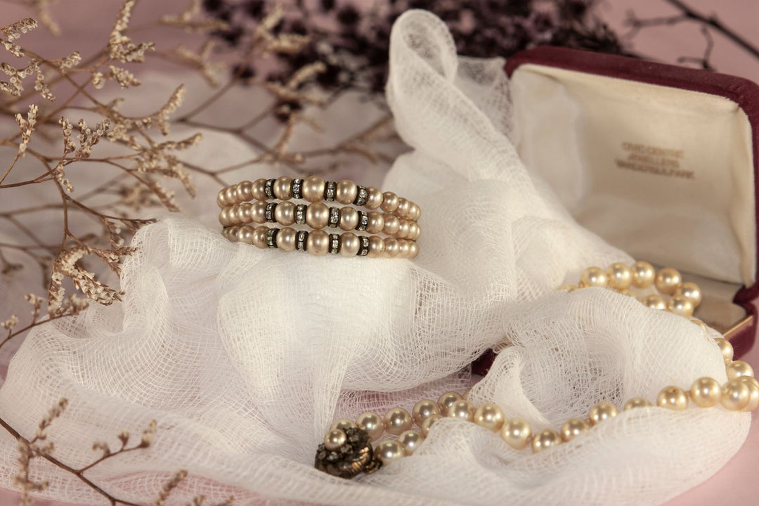 Pearl jewelry arranged on soft fabric with flowers as an elegant gift