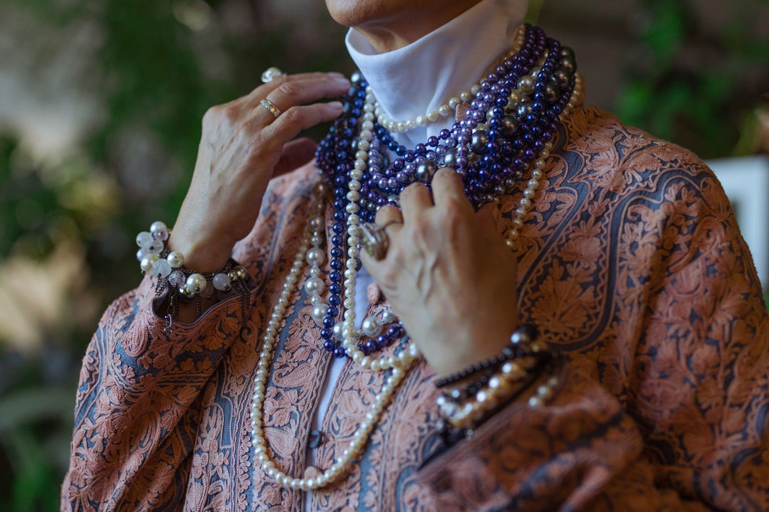 Woman wearing layered pearl necklaces in different lengths